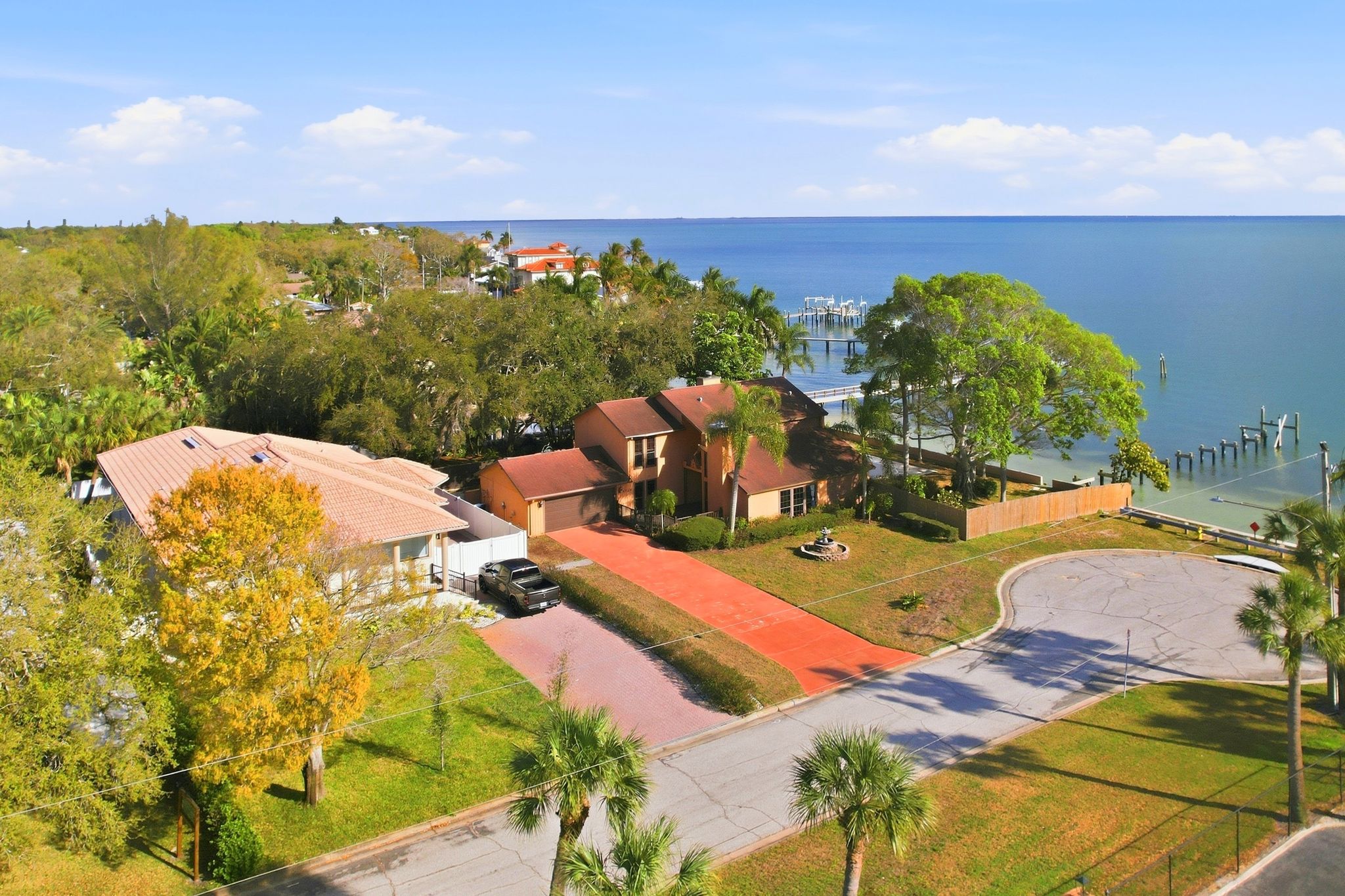 Aerial view of 6755 30th Street South from above, showing the cul-de-sac, circular drive, and neighboring parcel with Tampa Bay beyond
